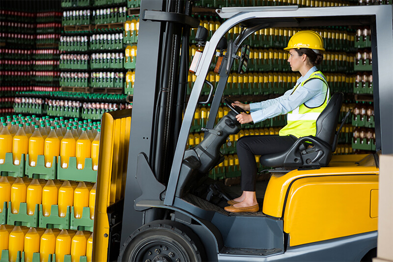 employee driving a fork truck and moving 2 liter soda bottles