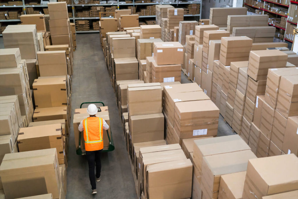 employee moving boxes in a room full of large boxes